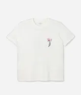 Remera de algodón color blanco crudo, manga corta y cuello redondo, con un pequeño estampado floral y lettering en el área del pecho.