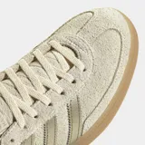 Championes Adidas Handball Spezial de gamuza en color beige, con las clásicas tres tiras metalizadas en tono dorado, talón a juego, inscripción "SPEZIAL" lateral y suela de goma translúcida.