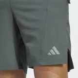 Short deportivo Adidas Designed For Training de color gris, con cintura elástica, cordón ajustable y bolsillos frontales con cierre. Cuenta con el logo de la marca en una de las piernas y aberturas laterales en el dobladillo.
