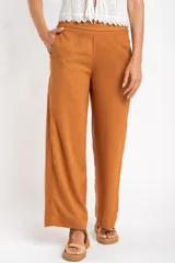 Pantalón de lino color tostado, de corte recto y tiro medio.
