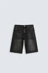 Bermuda de denim color negro lavado, estilo baggy fit, con cinco bolsillos y cierre frontal de cremallera y botón.