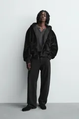Cazadora bomber reversible de corte relajado confeccionada en tejido técnico. Presenta capucha con interior de pelo sintético, cierre frontal con cremallera de doble dirección, bolsillos laterales y puños y bajo con acabado en rib elástico.