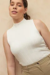 Top tejido de punto color coral, de cuello alto y sin mangas, corte ajustado.