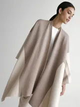 Poncho tipo spolverino bicolor, beige y visón, con diseño geométrico.