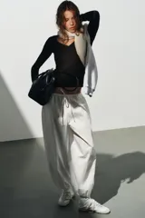 Pantalón confeccionado en mezcla de algodón y poliamida, color blanco, de tiro medio con cintura elástica y cordón ajustable. Posee bolsillos laterales y bajo abullonado con terminación en elástico.