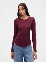 Remera de manga larga confeccionada en tejido tipo waffle, con cuello redondo y ruedo redondeado.