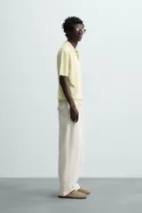 Polo de punto tejido de algodón con efecto lavado, color amarillo pálido. Presenta un calce regular fit, cuello solapa con cierre frontal de tres botones y manga corta.