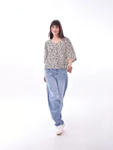 Blusa blanca de mangas cortas, con cuello redondo y abotonada al frente.