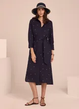Vestido camisero midi color azul marino con estampado de lunares blancos, cuello camisero, mangas 3/4 y cinturón de lazo.