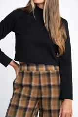 Polera de manga larga color marrón jaspeado, con cuello alto y corte ajustado al cuerpo.