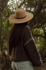 Sweater marrón de tejido de punto grueso con mangas largas y costuras blancas decorativas.