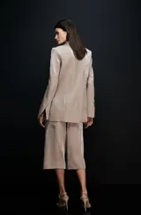 Blazer de mujer con acabado metalizado en tono champagne, solapas clásicas y hombros definidos con estructura, diseño de líneas depuradas.