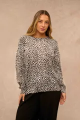 Buzo de punto con estampado animal print tipo dálmata en tonos gris y blanco, de manga larga y cuello redondo.