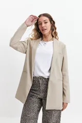 Blazer color beige estilo lino, de corte recto y largo a la cadera.