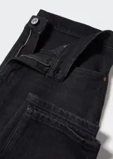 Jeans mom fit de tiro alto en color negro, confeccionados en denim elástico con diseño de cinco bolsillos, trabillas para cinto y cierre frontal con cremallera y botón.