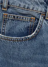 Pantalón de jean de tiro medio con diseño recto y cinco bolsillos. Presenta aberturas laterales en el bajo y cierre frontal con cremallera y botón.