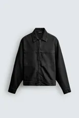 Sobrecamisa de corte regular fit confeccionada en denim de algodón con efecto lavado. Presenta cuello solapa, cierre frontal con cremallera, bolsillos de plastrón en el pecho y mangas largas con puños abotonados.