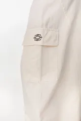Pantalón cargo color beige de tiro bajo y corte ancho, con bolsillos laterales utilitarios.