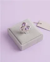 Anillo de plata 925 con diseño cruzado y piedra amatista en forma ovalada.