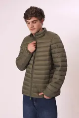 Chaqueta acolchada tipo puffer, color azul marino, con cuello alto y cierre frontal de cremallera.