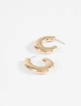 Aros tipo argolla gruesos con diseño semi ovalado y acabado brillante en color plateado.