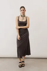 Vestido largo color verde suave, sin mangas, con escote redondo y silueta al cuerpo que se ensancha levemente hacia el dobladillo.