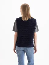 Chaleco de punto calado color mostaza, de silueta recta y calce suelto, con escote en V pronunciado y sisas rectas.