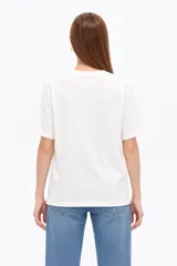 Remera negra de algodón, manga corta, con cuello redondo y diseño gráfico estampado en el pecho que incluye un sol, flores y la leyenda 'Since 1973'.