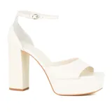 Sandalias de plataforma color blanco, con tira delantera ancha, pulsera al tobillo con hebilla metálica y tacón cuadrado.