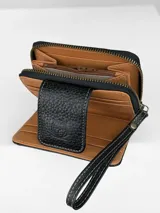 Billetera compacta de cuero negro con diseño combinado de textura granulada y efecto crocco brillante. Cuenta con cierre perimetral, solapa frontal con broche y logo grabado, e incluye una correa de muñeca extraíble.