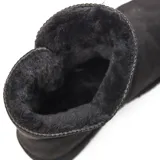 Bota corta tipo australiana color negro con acabado gamuzado, forro interno de piel sintética y detalle de botón lateral con cierre elástico.