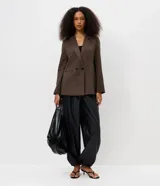 Pantalón aladín de poliuretano color negro, de corte ancho con diseño abullonado y botamangas elásticas ajustadas, con cintura elástica.