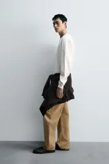 Sudadera negra de corte relaxed fit, confeccionada en tejido técnico interlock de algodón con elasticidad. Presenta cuello redondo, manga larga y una etiqueta aplicada en el bajo. Los acabados son en rib.