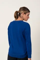 Buzo deportivo celeste de algodón, con cuello redondo y terminación en volado cruzado en el ruedo.