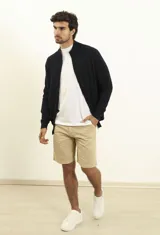 Cardigan azul de tejido de punto con cierre frontal, cuello alto y bolsillos laterales.