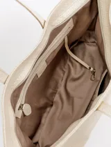 Cartera shopper grande de cuero color beige con diseño trenzado. Cuenta con asas largas de hombro, cierre superior y forro interior con bolsillos.