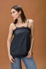 Musculosa de breteles finos con diseño a cuadros oscuros, decorada con delicados detalles de puntilla negra en el escote, laterales y ruedo. Presenta un corte holgado y fluido.