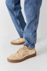 Zapatillas bajas color verde militar de gamuza con suela marrón y detalle trasero en color crema.