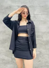 Camisa negra de manga larga con botones dorados, corte holgado y cuello clásico. Ideal para usar abierta sobre un top o cerrada como prenda principal.