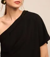 Blusa negra de crepé con un solo hombro, escote drapeado y manga corta.