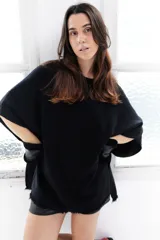 Poncho celeste de tejido de punto con cuello redondo y terminación desflecada.