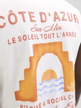 Musculosa de corte oversize confeccionada en algodón, color blanco, con diseño estampado en la espalda que incluye motivos veraniegos y tipografía en tonos naranja y azul.