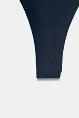 Body strapless de corte ajustado, confeccionado en tejido de poliamida, con cierre inferior mediante botones a presión.