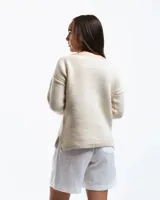 Buzo de lana merino con cuello bote y mangas largas. Presenta un detalle bordado a mano en color azul en la parte inferior.