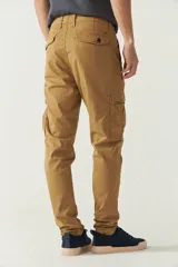 Pantalón cargo gris para hombre, de corte regular, con bolsillos laterales y traseros con solapa, pasacinto y logo metálico. Confeccionado en algodón y spandex.