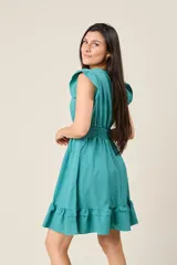 Vestido corto blanco con cuello en V, mangas cortas con volados, cintura elastizada y falda con volados.