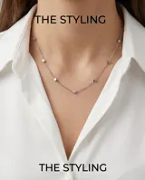 Collar de cadena fina de acero con pequeños dijes en forma de cubo distribuidos a lo largo de la pieza.