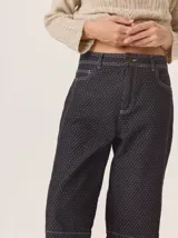 Pantalón de corte barrel en tejido de pana con estampado geométrico sutil y costuras a la vista. Presenta tiro medio, cierre frontal con botón y bolsillos laterales.