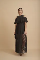 Vestido largo negro con hombros descubiertos, volados en el pecho, mangas cortas y paneles de encaje transparente en la falda.