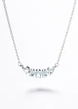 Collar de plata 925 con cinco piedras de topacio celeste engarzadas en forma de arco, con engaste tipo bisel. La cadena es de eslabones finos.